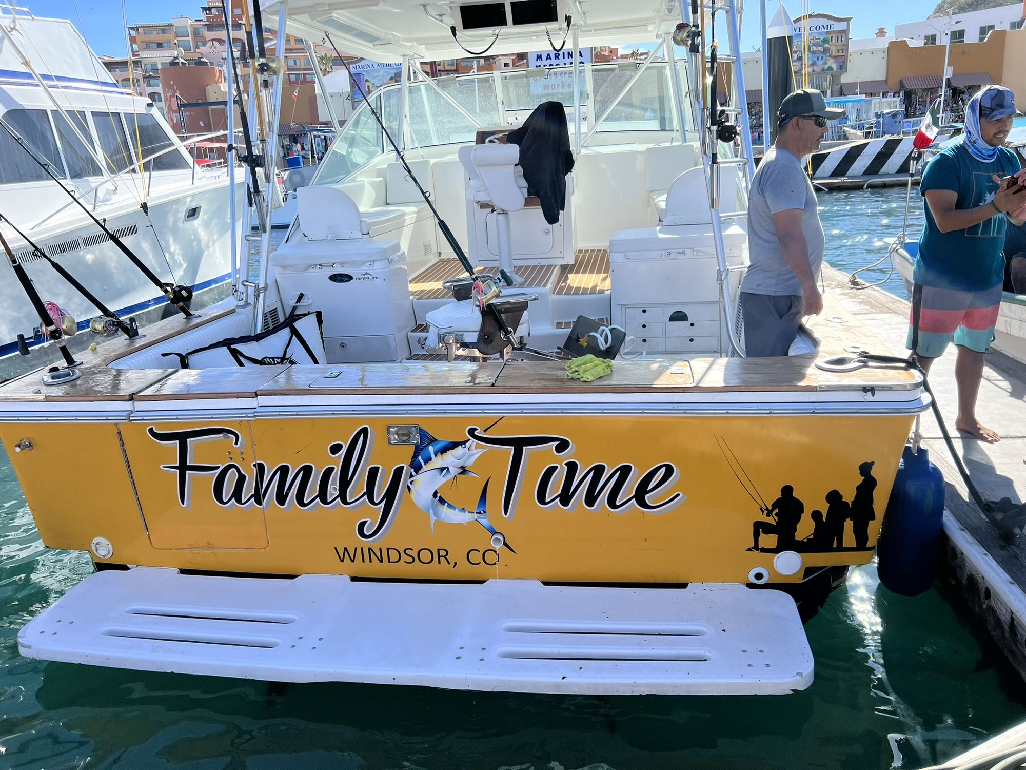 The gold transom of Family Time with its script lettering and marlin, moored at Marina Mercado